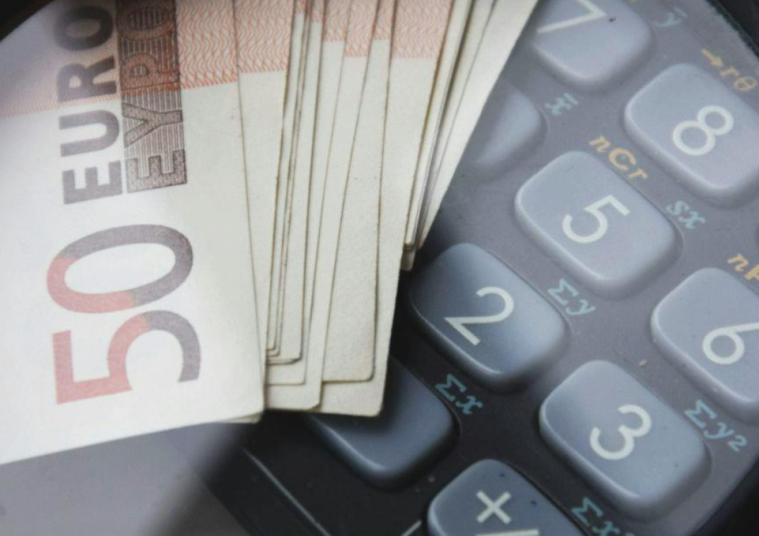 Een bundeltje geld ligt op een rekenmachine