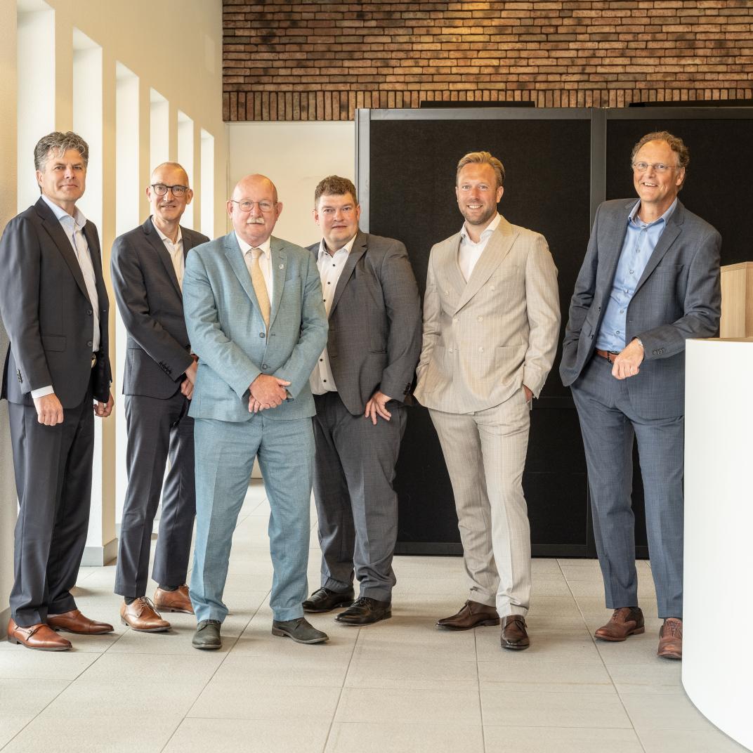 6 mannen in pak staan op een rijtje