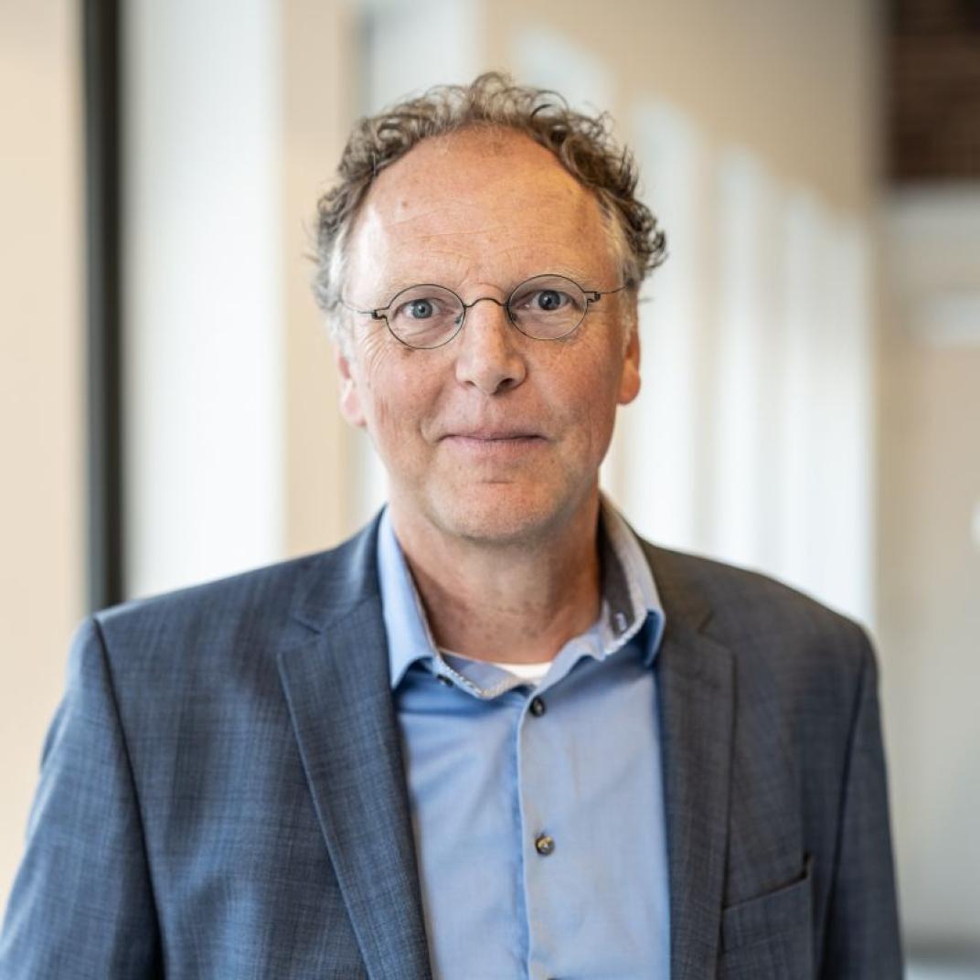 Man in pak kijkt recht in de lens